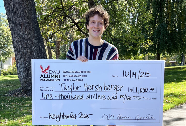 Photo of scholarship winner holding a big fake check.